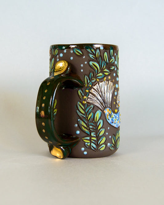Decorative mug with nature-themed design on a light background