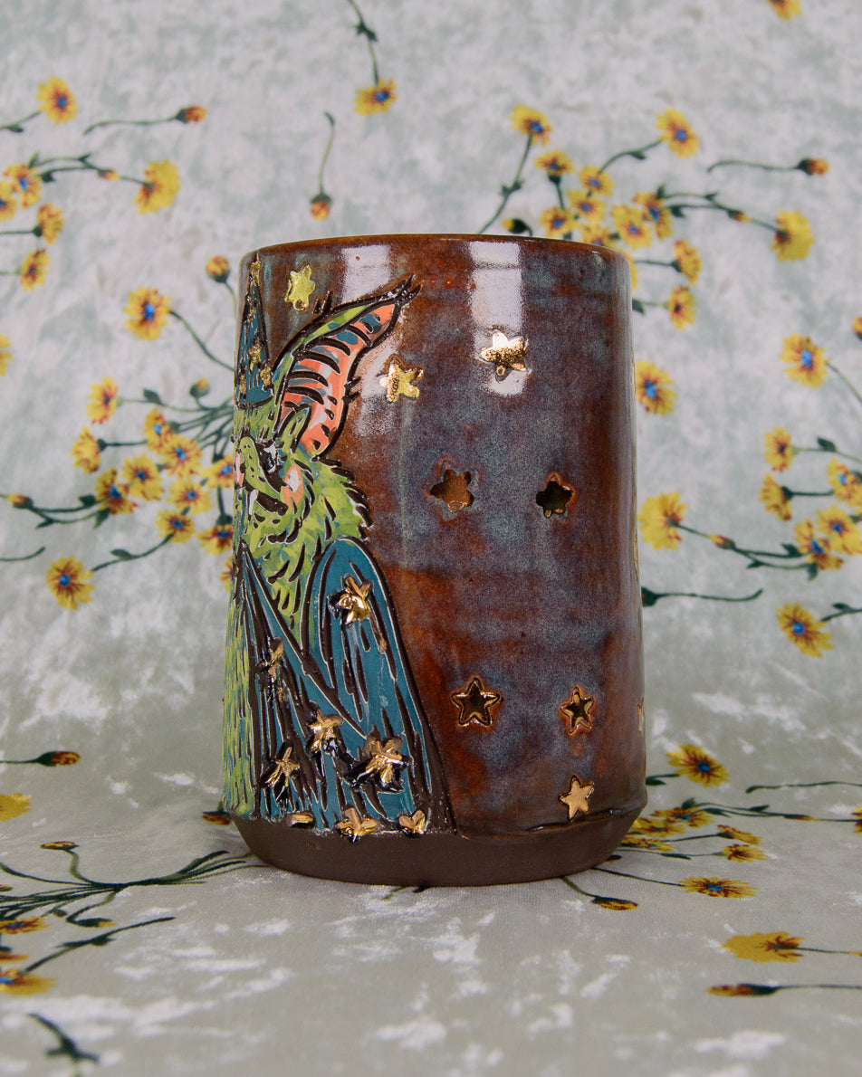 Ceramic tumbler with wizard bat design on a floral patterned background