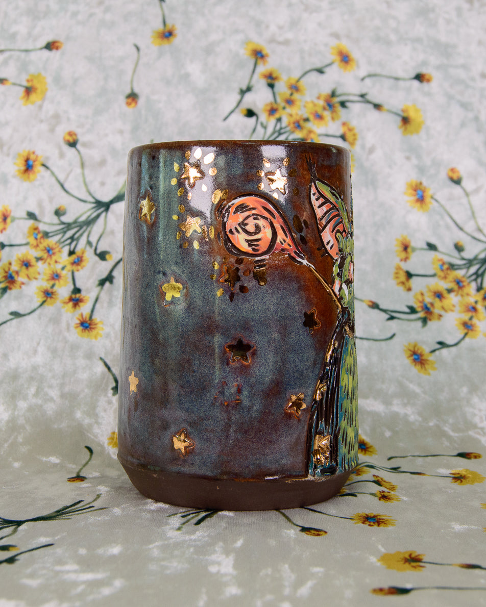 Ceramic mug with cartoon design and gold stars on a floral background