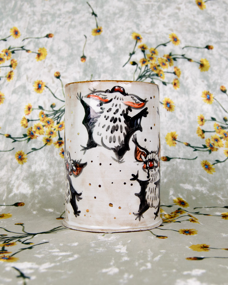 Ceramic cup with black and white dancing bats designs on a floral background