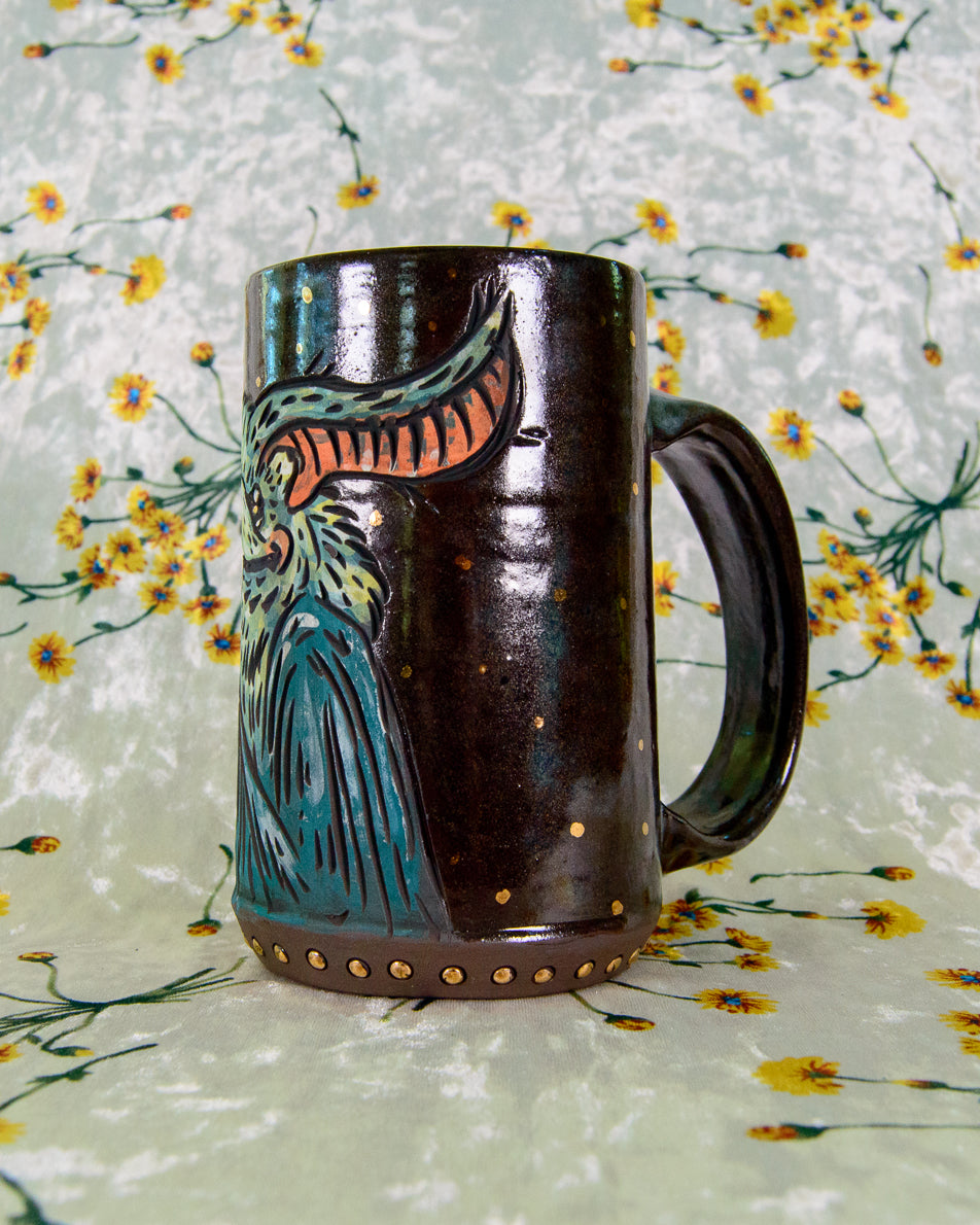 Decorative ceramic mug with a bat design on a floral-patterned background