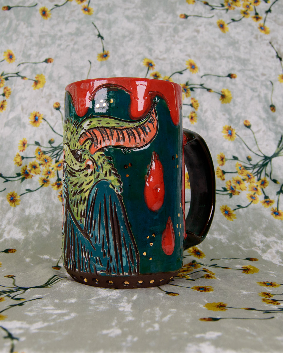Colorful ceramic mug with a bat and blood drip design on a floral background