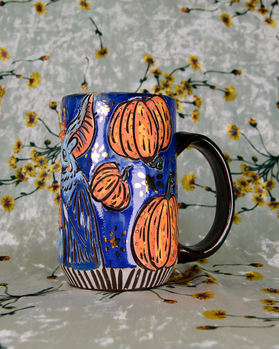 Ceramic mug with pumpkin design on a floral background