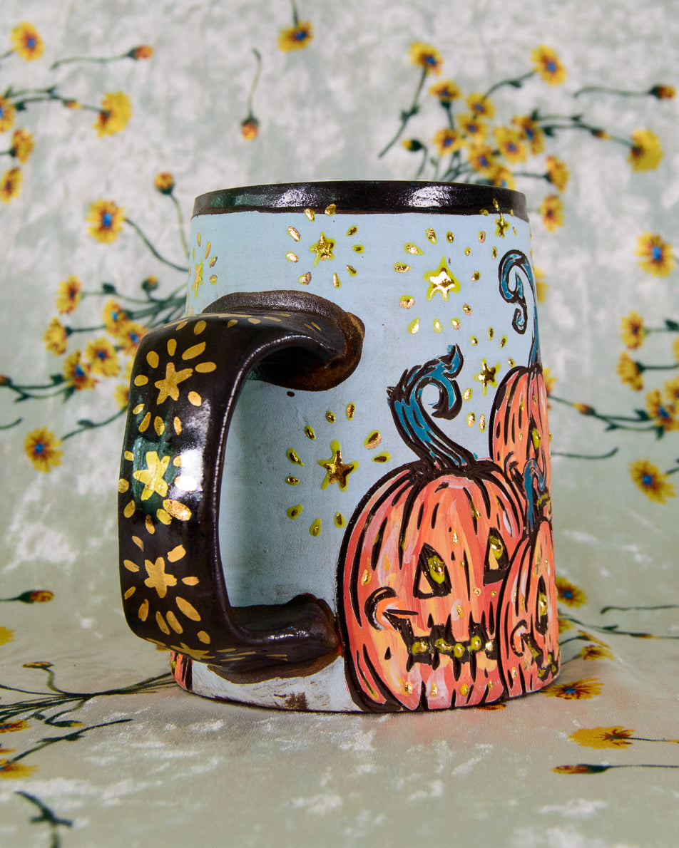 Ceramic mug with Halloween design featuring pumpkins on a floral background