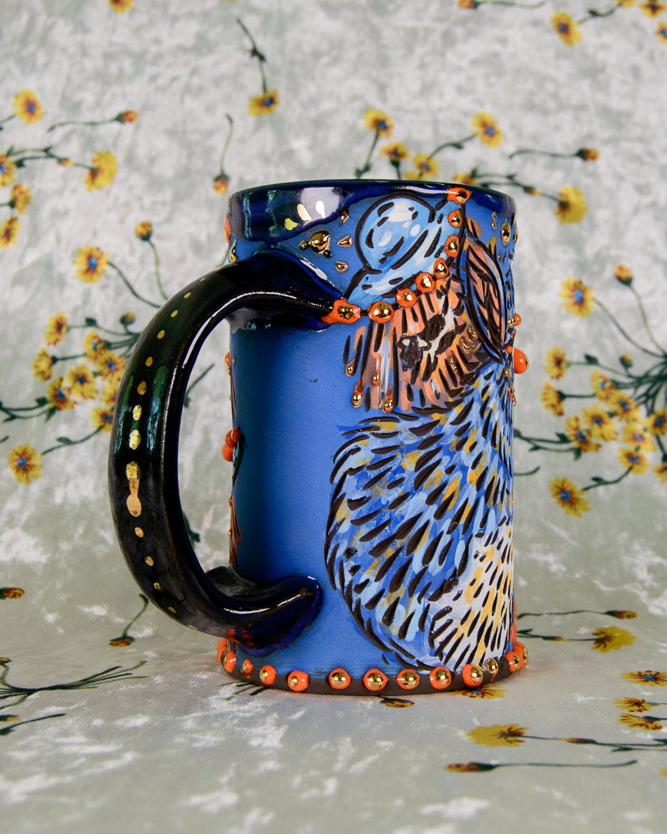 Blue mug with an alien UFO design and gold luster details on the handle