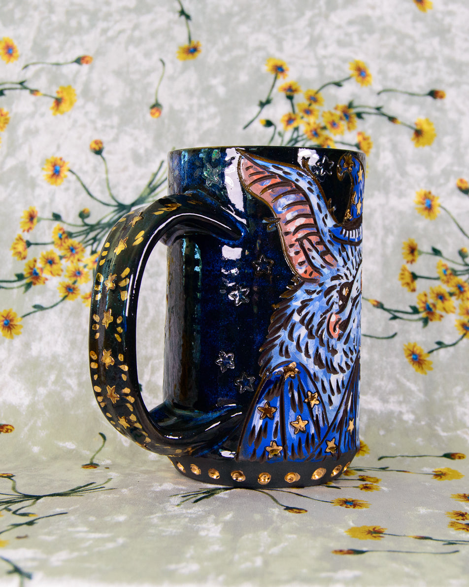 dark blue stoneware mug with gold and rainbow stars