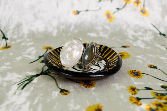 Two rings on a black dish with a floral patterned background