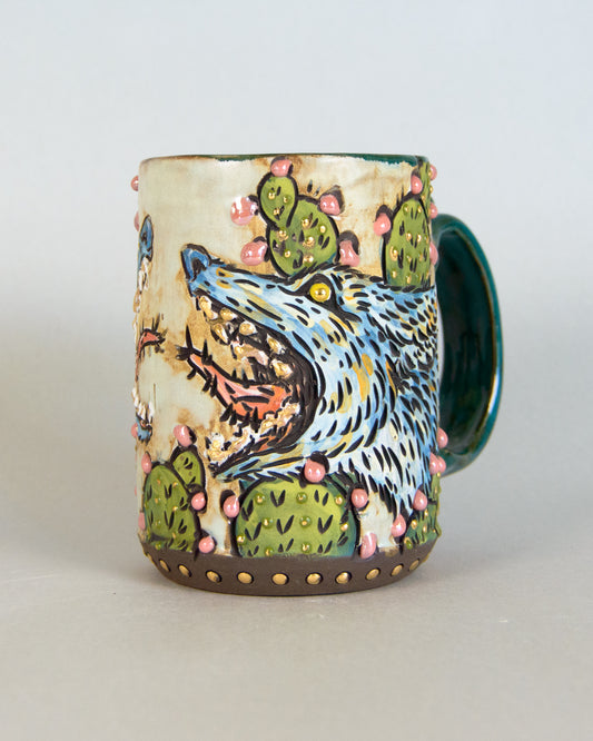 Ceramic mug with a coyote and cactus design on a white background