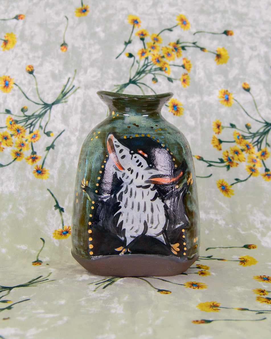 Decorative vase with a painted design of a dancing bat, shaking its butt on a floral background