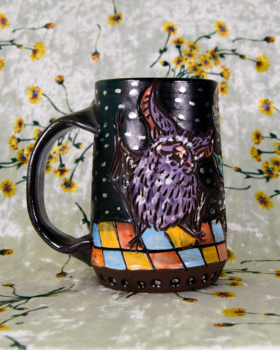 Black matte mug with purple dancing bat designs on a dance floor with silver accents