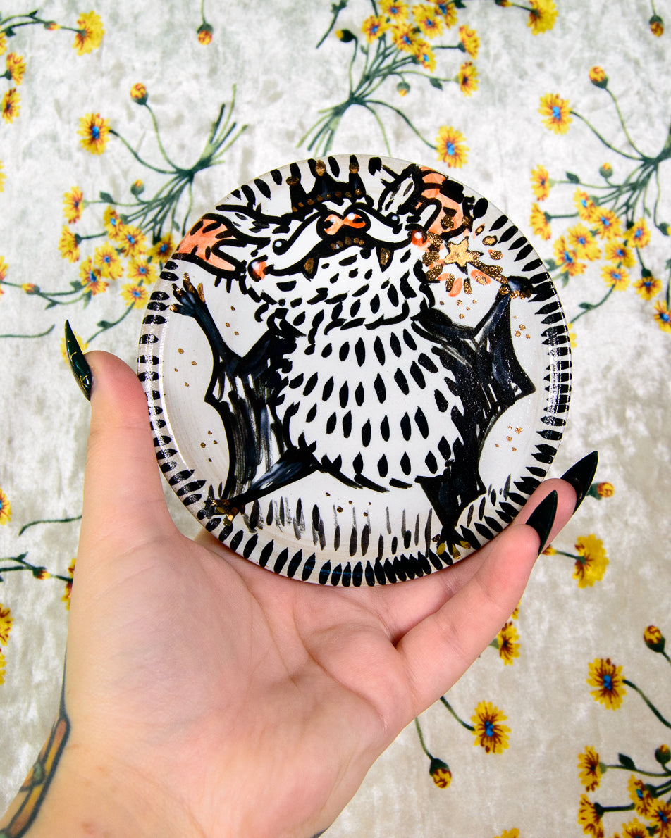 ceramic coaster with a cartoon black and white bat design