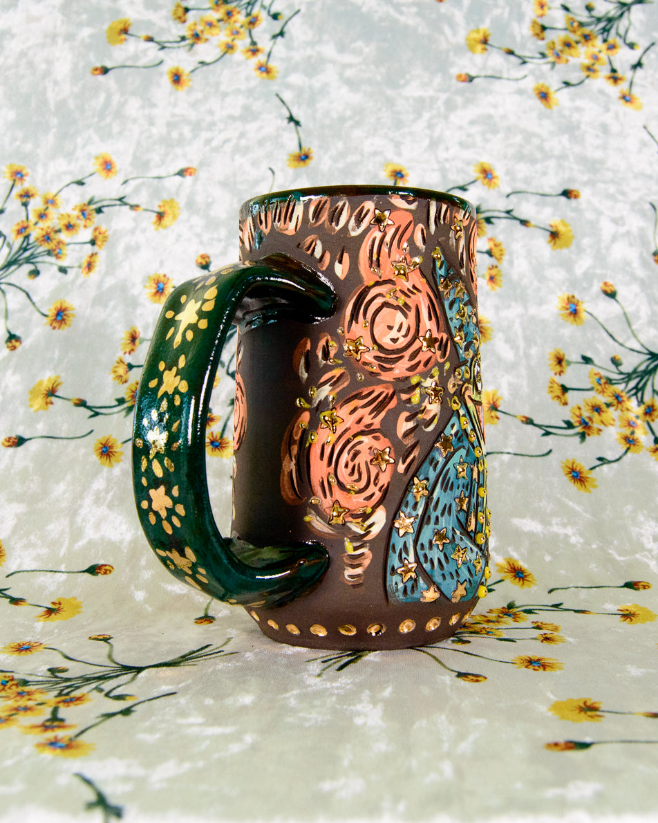 Decorative ceramic mug with artistic design on a floral background