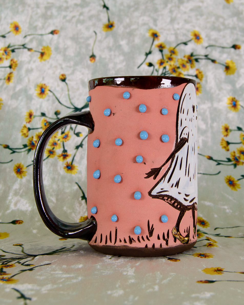 Mug with polka dot design and character illustration on a floral background