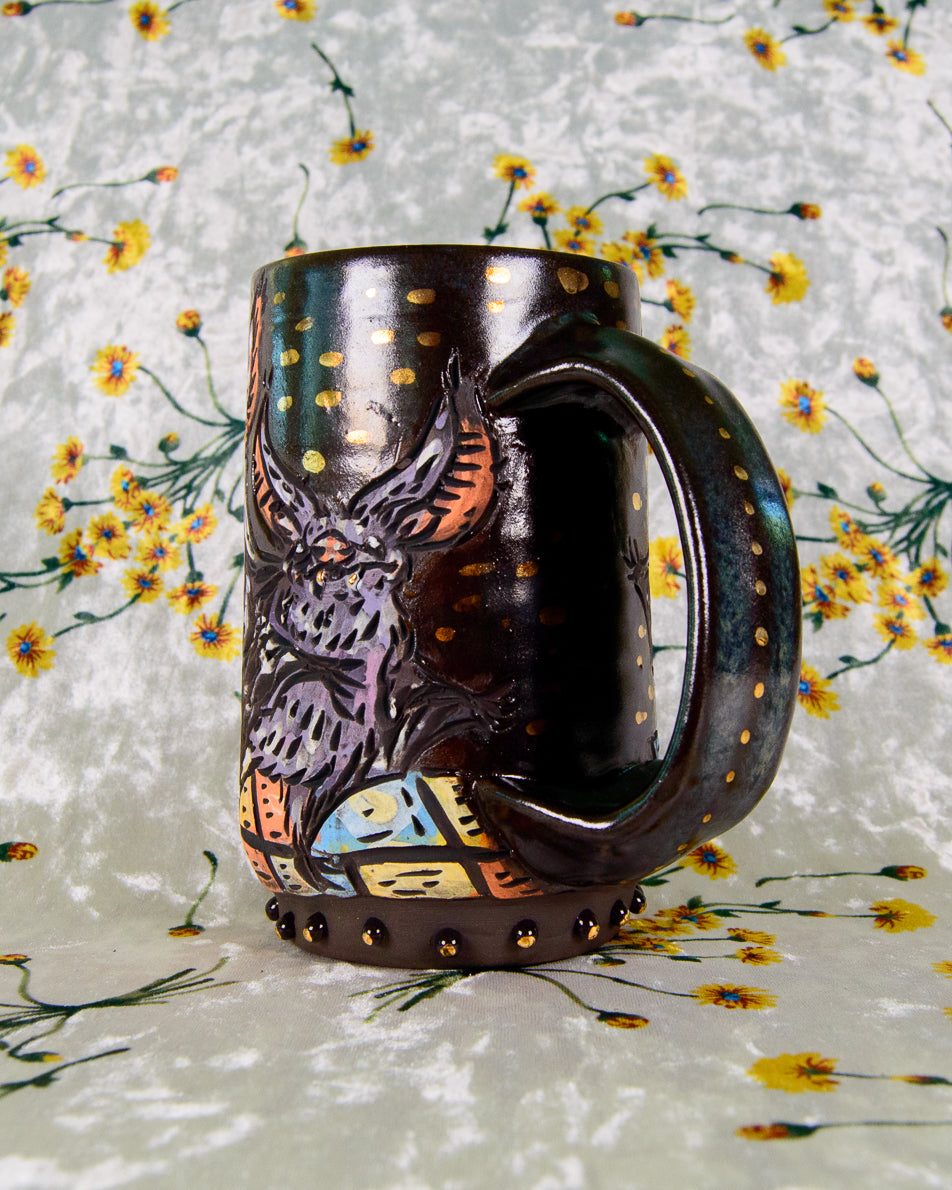 Decorative mug with a colorful design and gold dots on a floral-patterned background