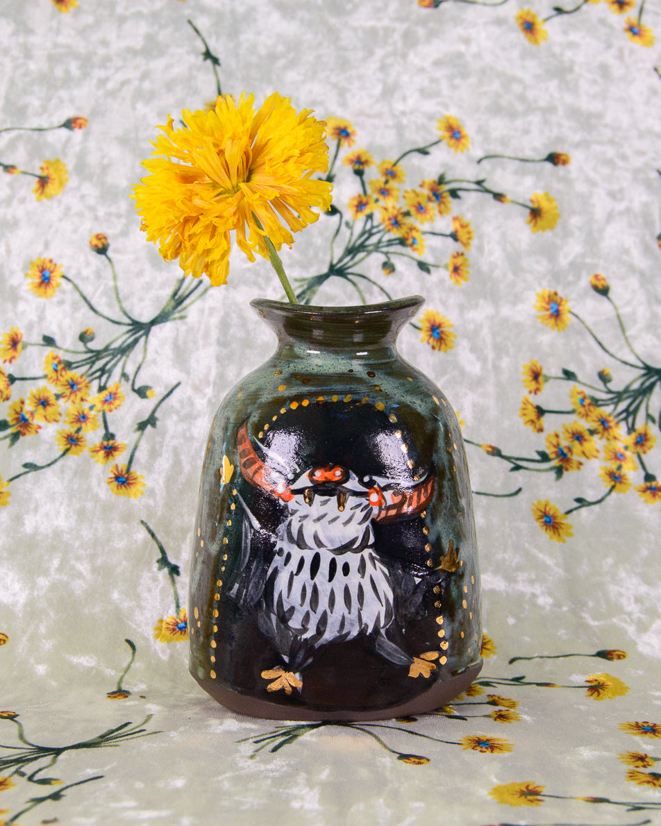 Decorative stoneware vase with a dancing bat design on a floral background