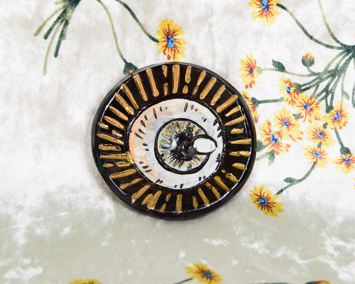 Handmade Ceramic Ring Dish with intricate eyeball design on a floral background