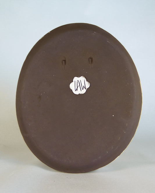 Round brown ceramic plate with a visible brand logo for lawful studios on a white background