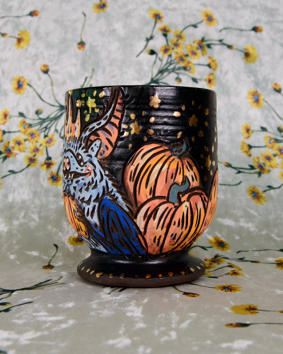 Decorative cup with animal designs on a floral background