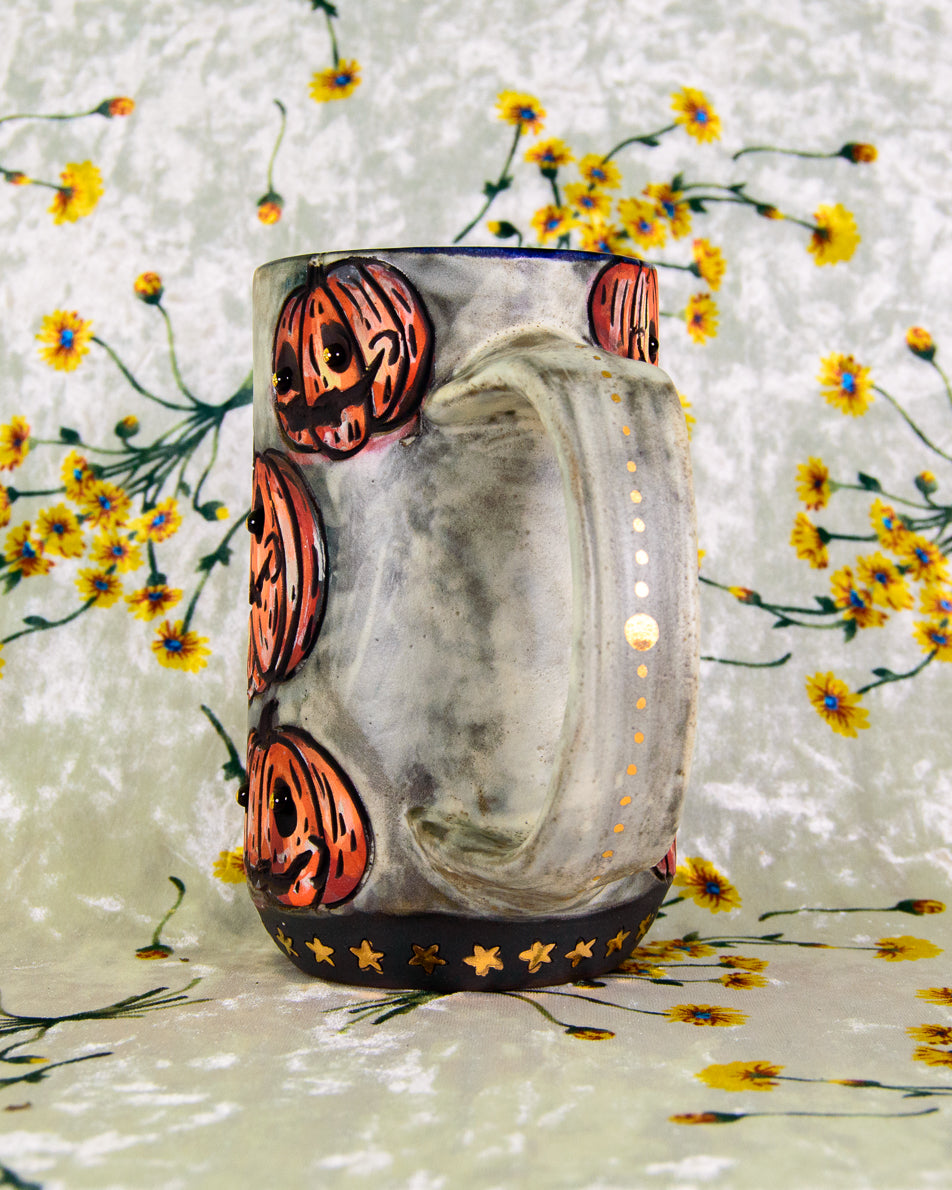 Decorative grey ceramic mug with gold luster details and dots on the handle