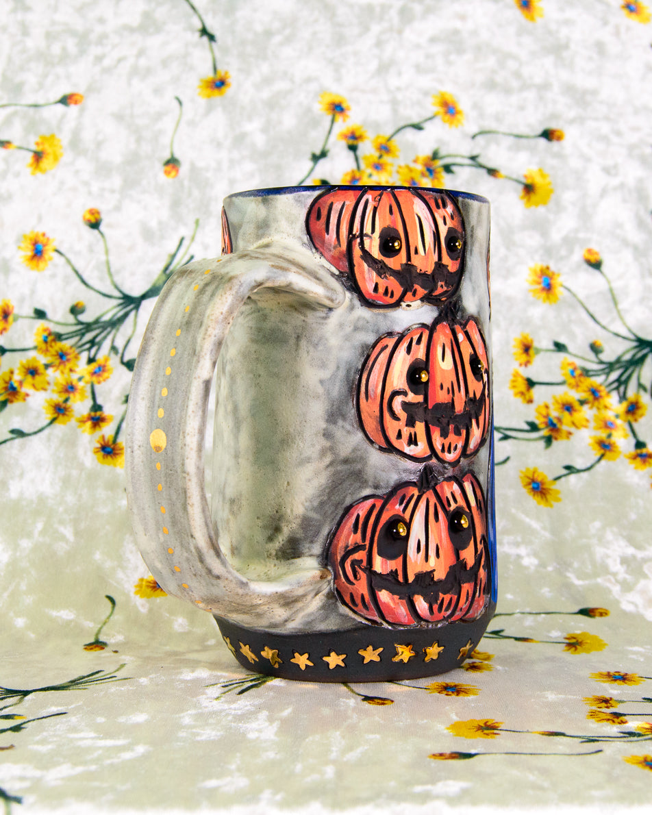 White ceramic mug with Halloween-themed pumpkin design on a floral background