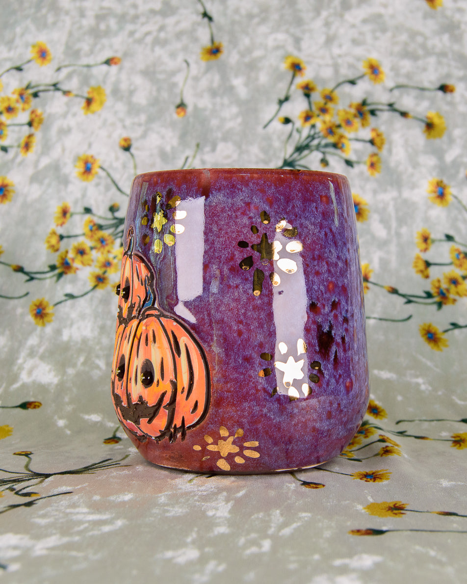 Purple ceramic wine cup with Halloween design on a floral background