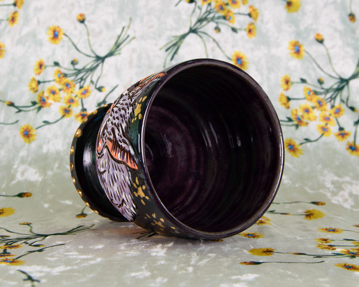 Ceramic cup with floral design on a floral-patterned fabric background