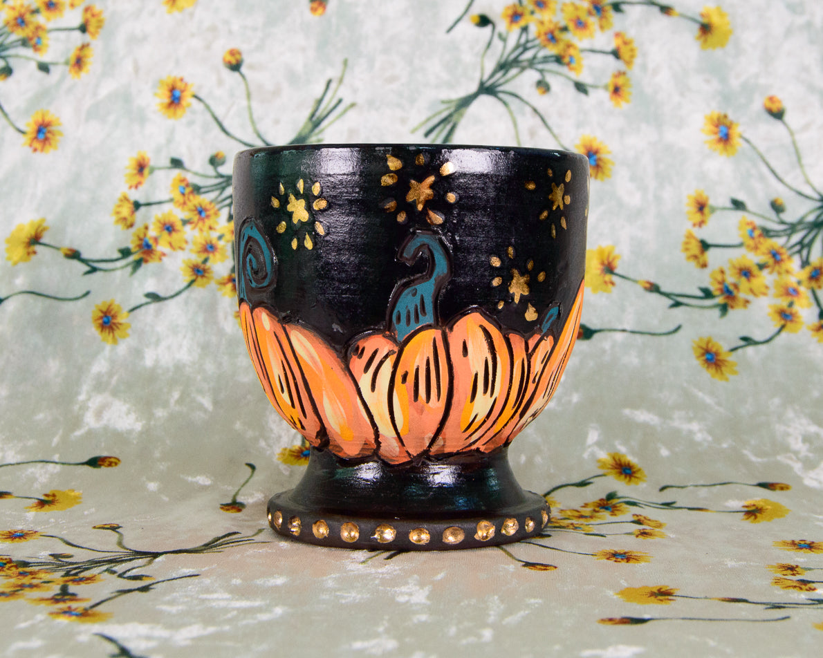Decorative ceramic cup with colorful designs on a floral background