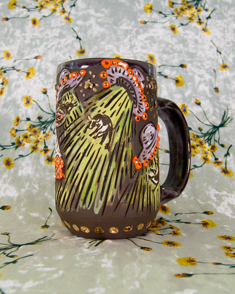 Ceramic mug with purple, orange, green, and gold alien ship designs and floating cartoon cows