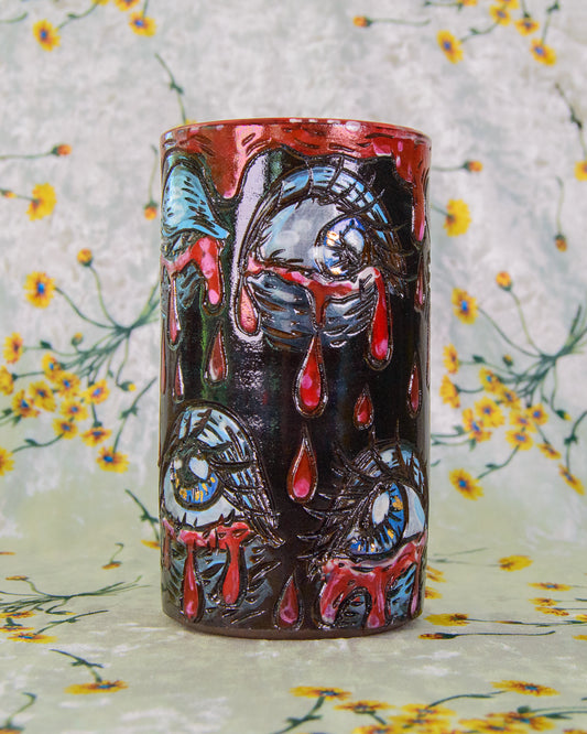 Ceramic highball cup decorated with crying blue and gold eyes.