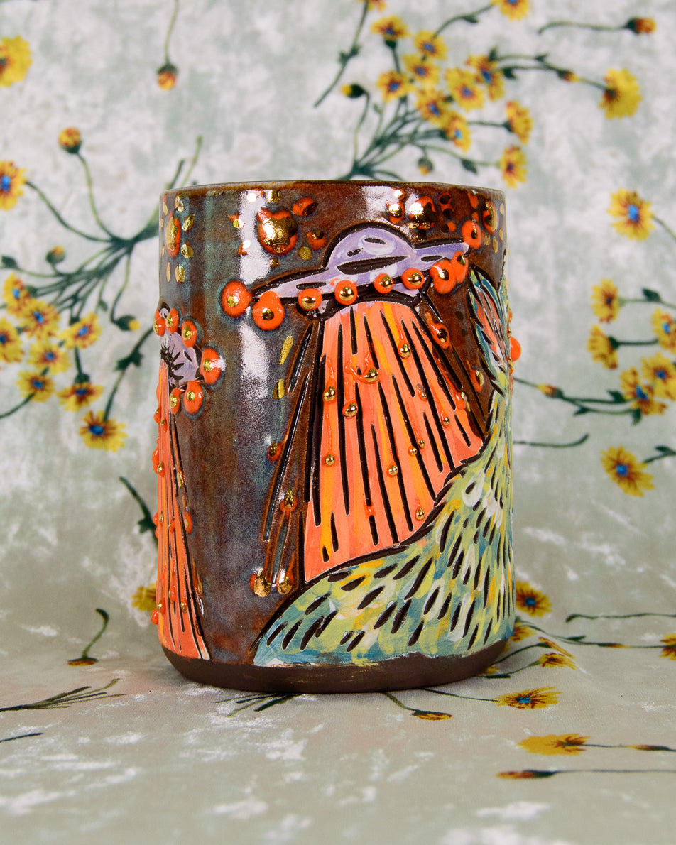 Decorative ceramic cup with artistic design on a floral background