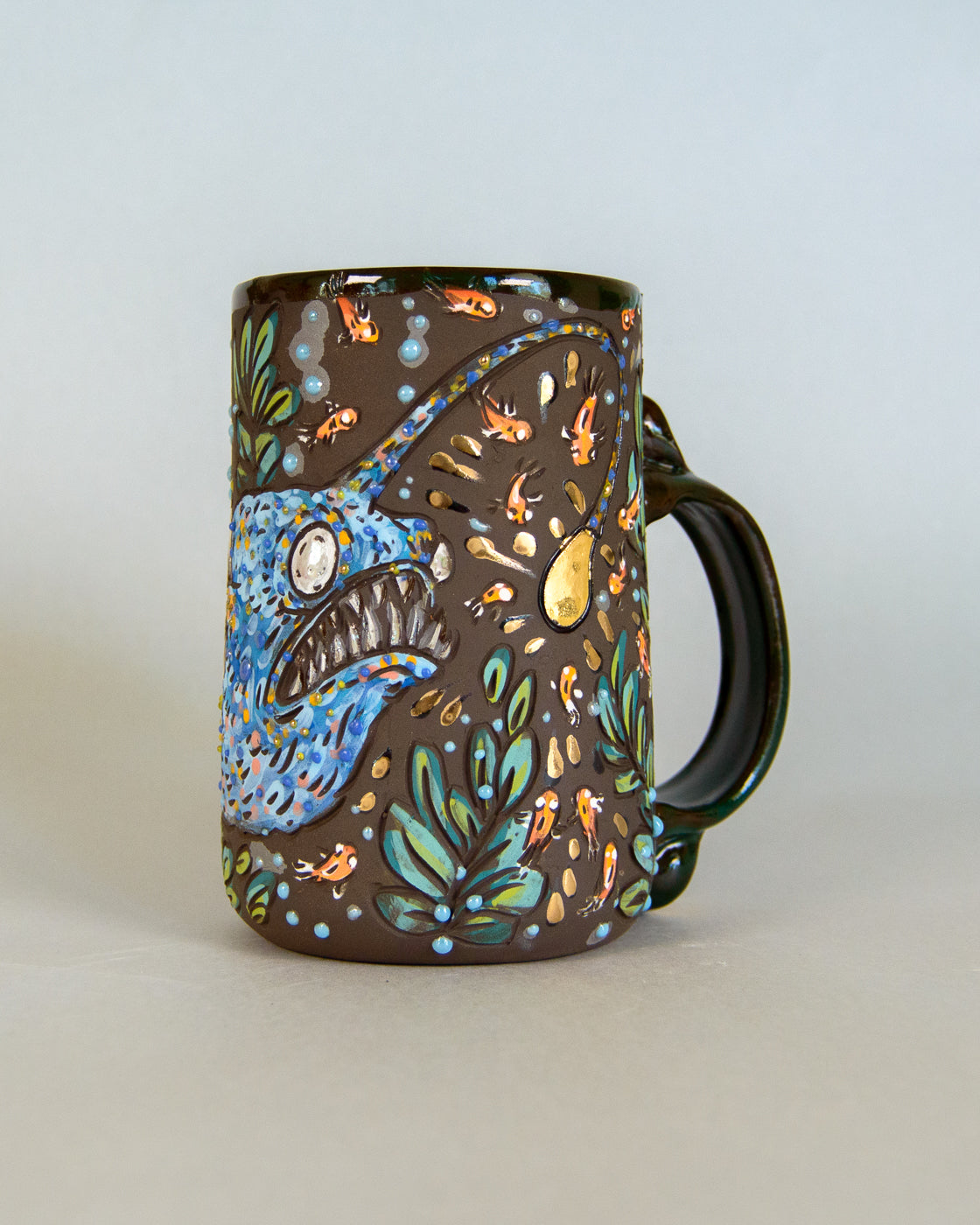 Decorative mug with a blue anglerfish design on a light gray background