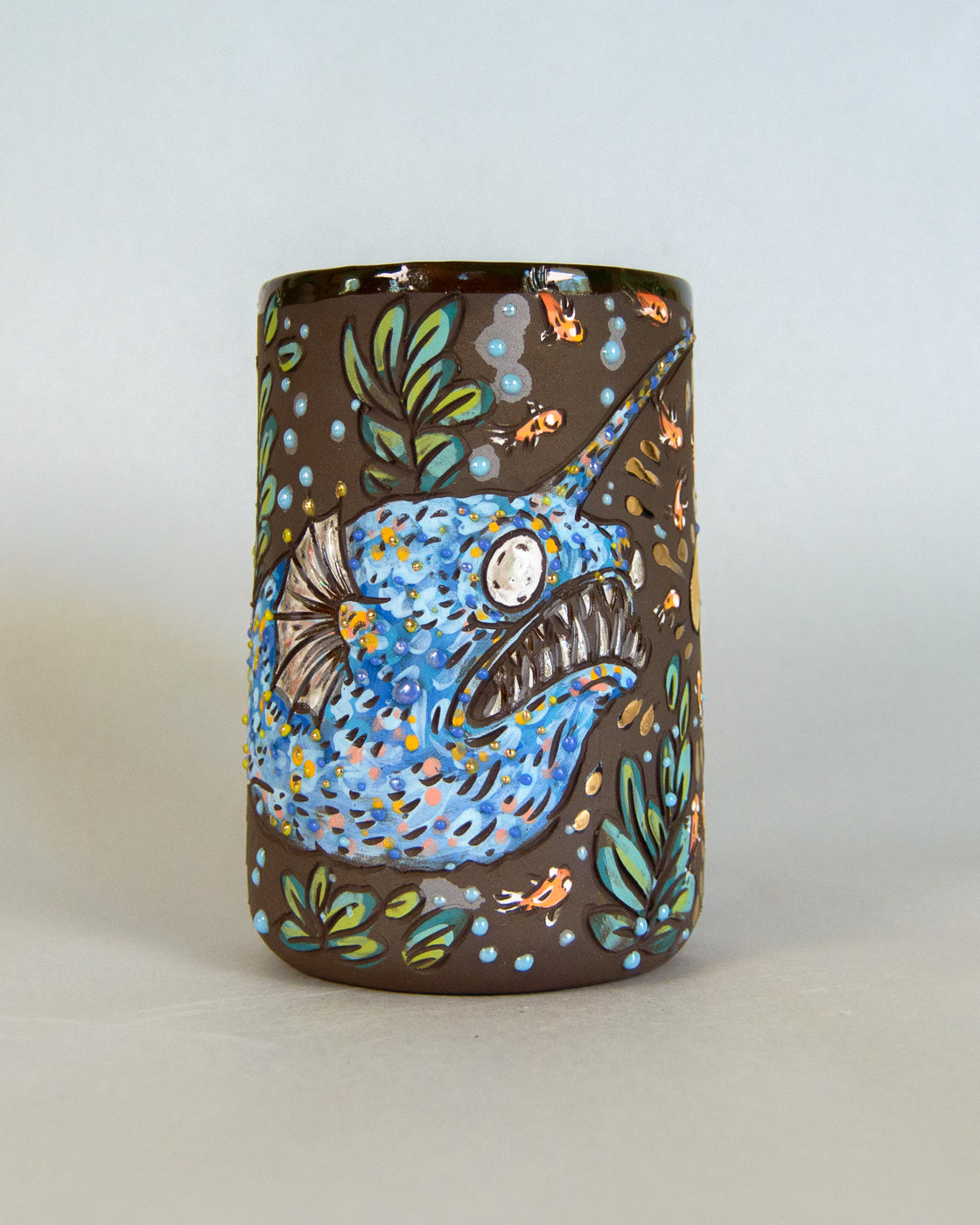 Decorative mug with a blue fish design on a plain background