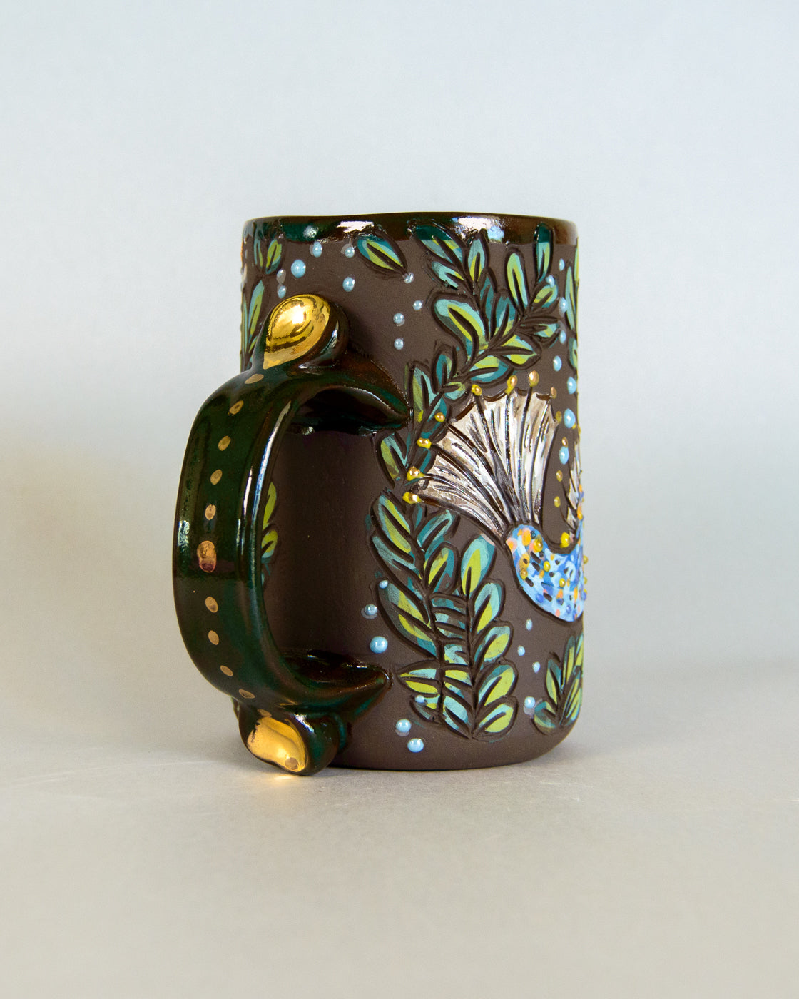Decorative mug with nature-themed design on a light background