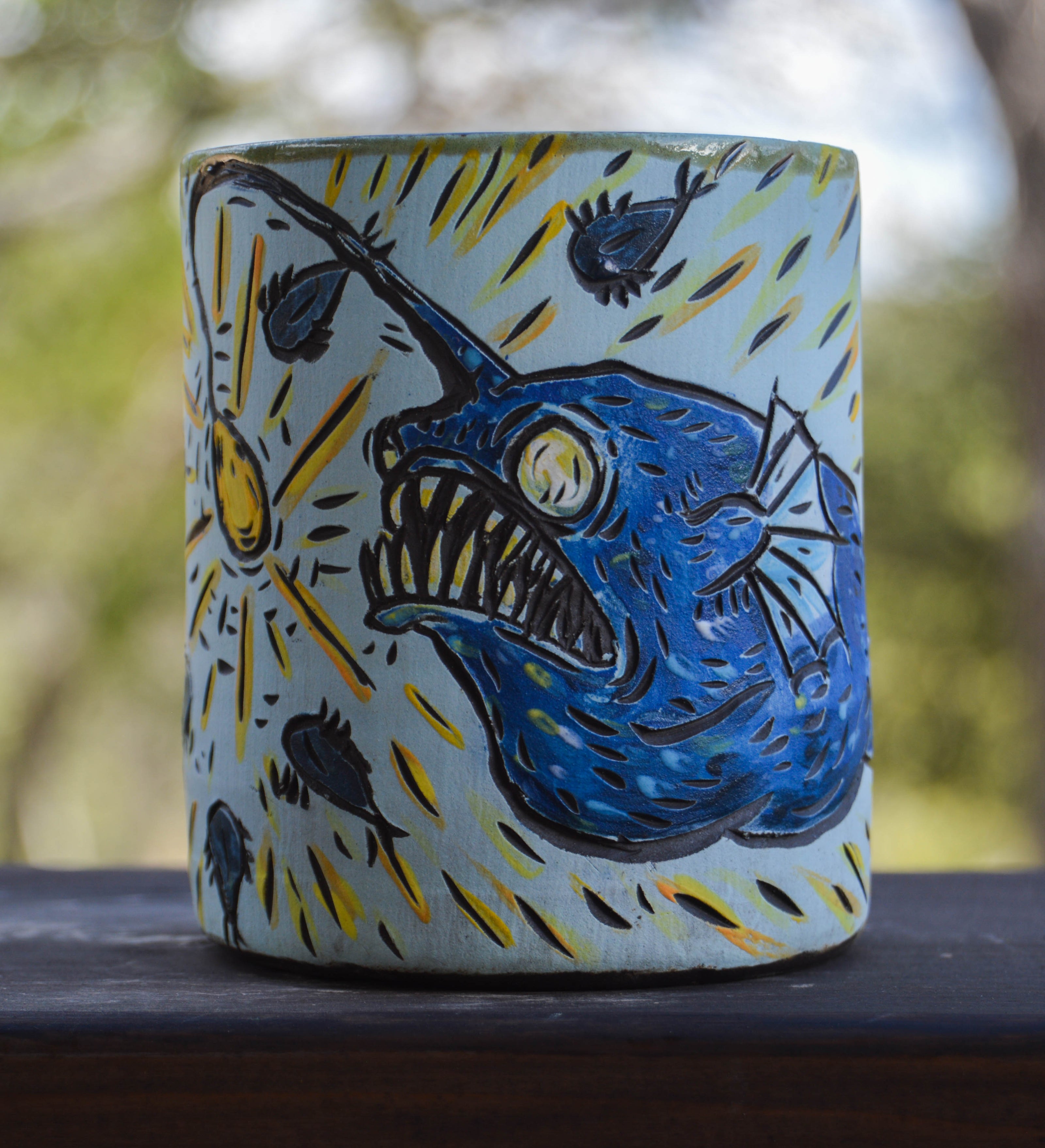 Handmade ceramic stoneware mug with a stylized anglerfish design