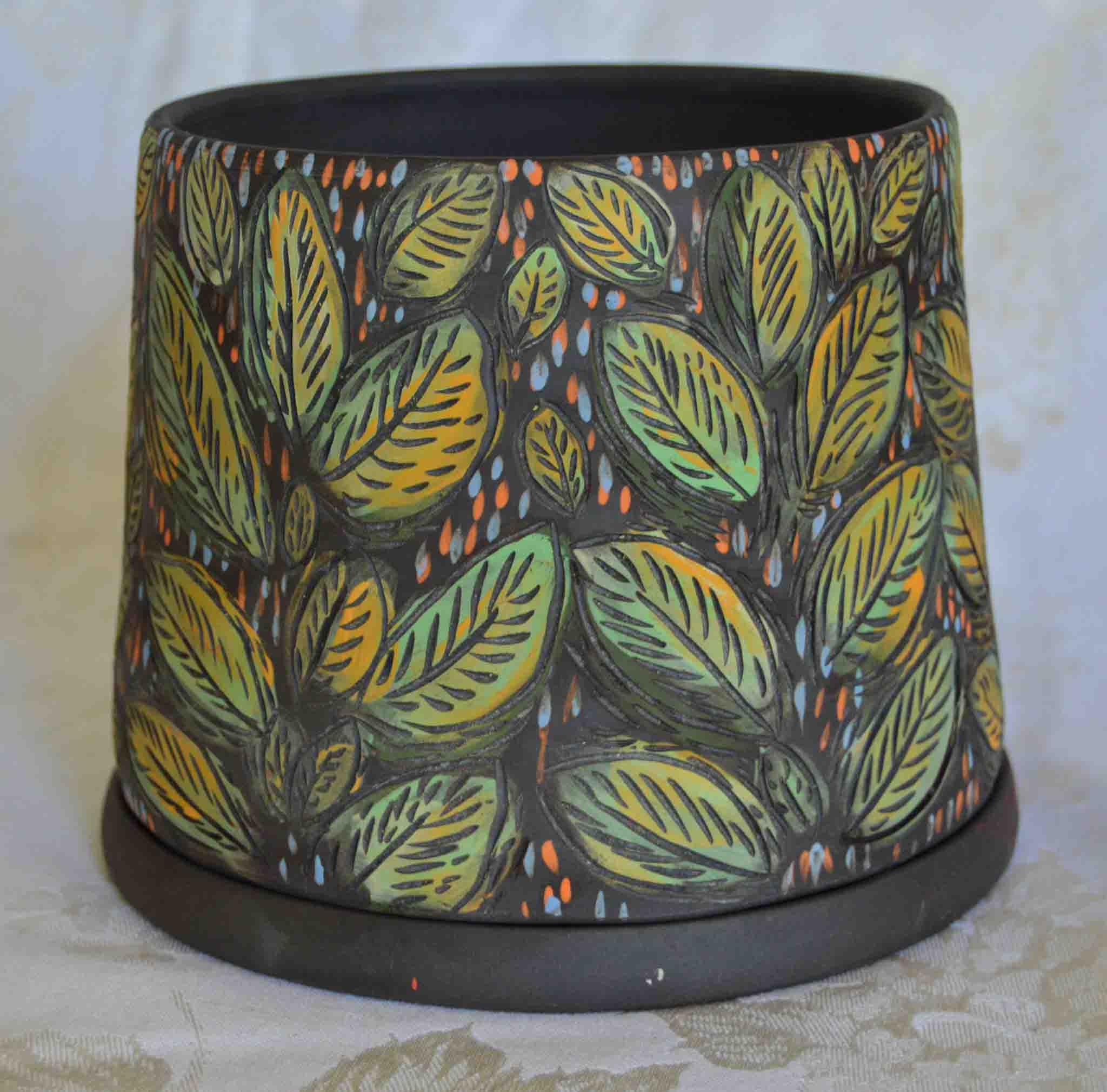 Ceramic planter with leaf pattern on a white background