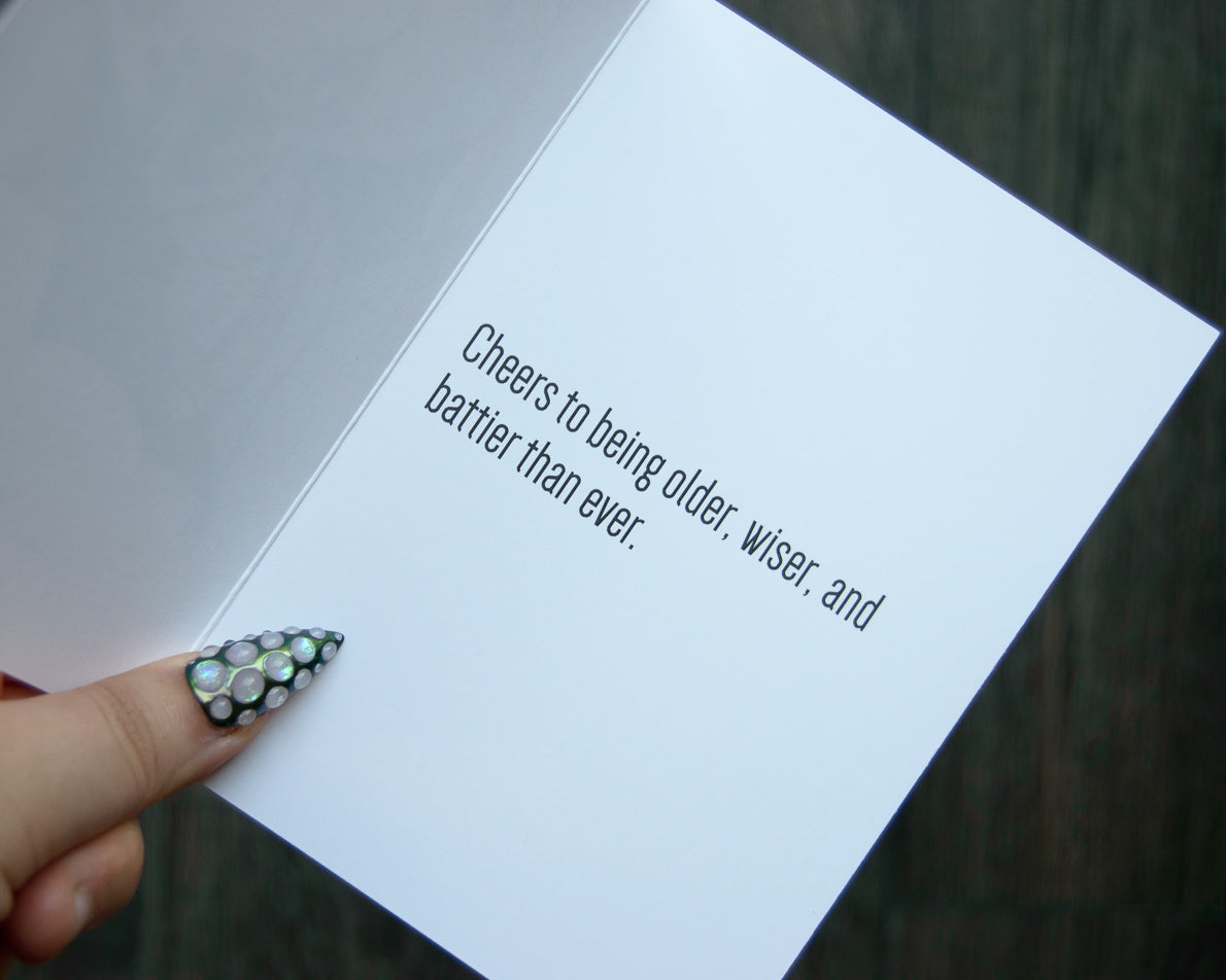 Hand holding a card with humorous birthday message.