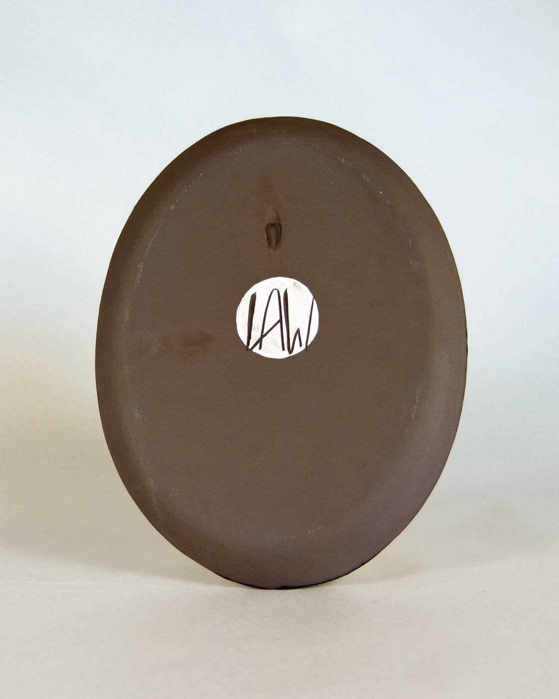 Brown ceramic plate with lawful studios logo on a white background