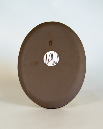 Brown ceramic plate with lawful studios logo on a white background