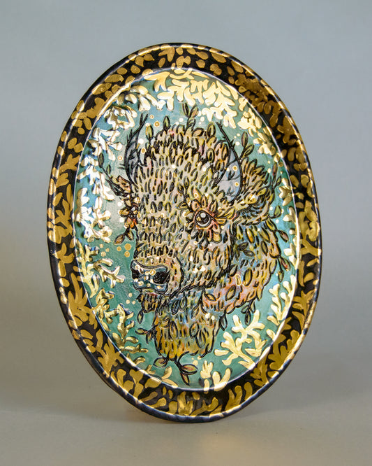 Decorative plate with a bison design on a gray background