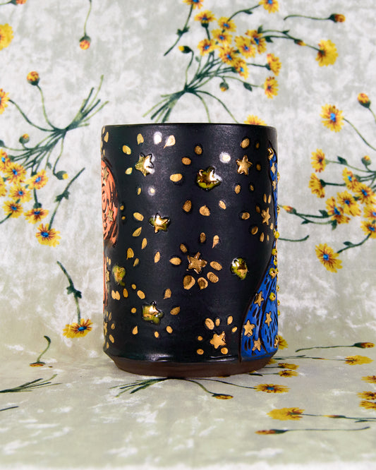 Whimsical 
Black matte ceramic cup with shiny gold star designs