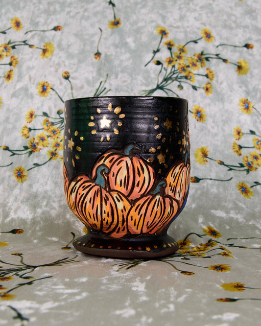 matte black ceramic goblet with soft black glaze, decorated with cartoon pumpkins and gold stars