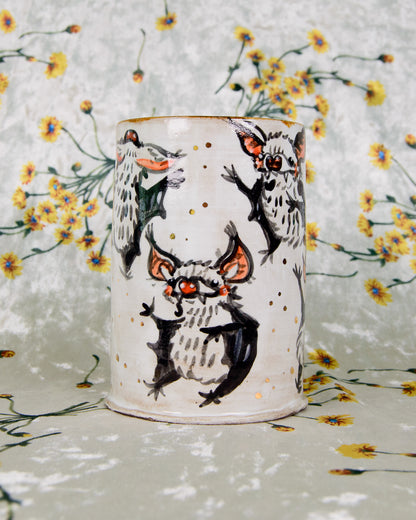 Ceramic cup with dancing bats designs on a floral background