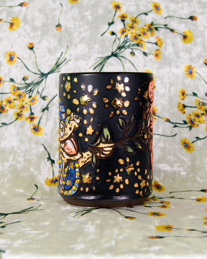 Black ceramic cup with a cartoon frog wizard design