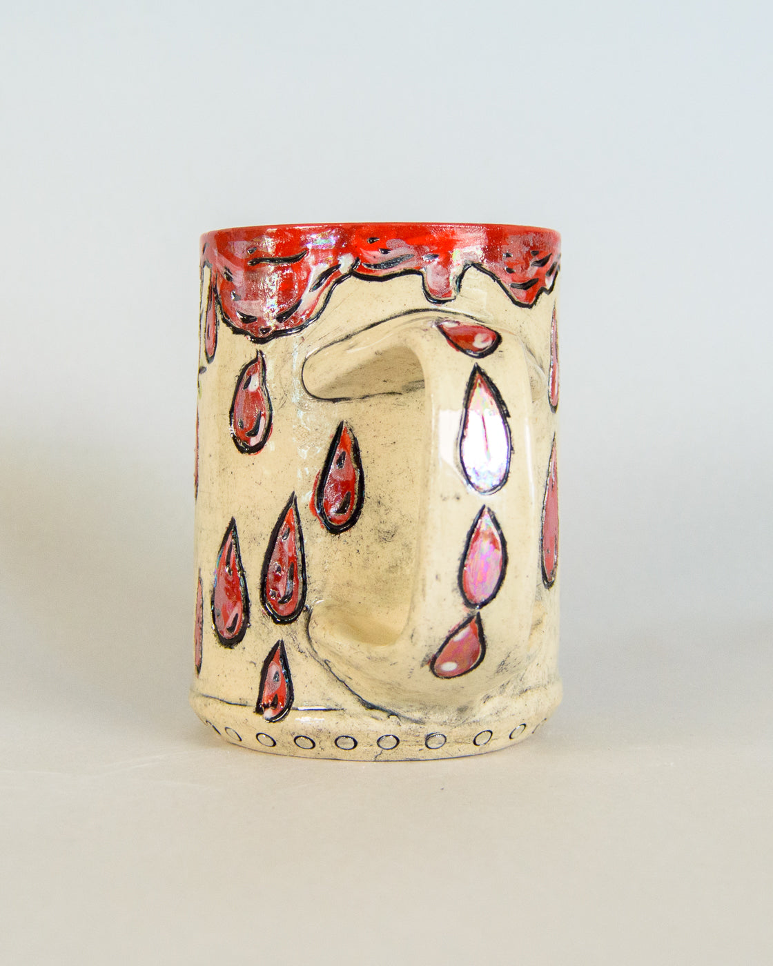 Ceramic mug with red blood drip designs on a white background