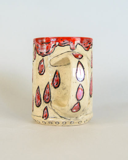 Ceramic mug with red blood drip designs on a white background