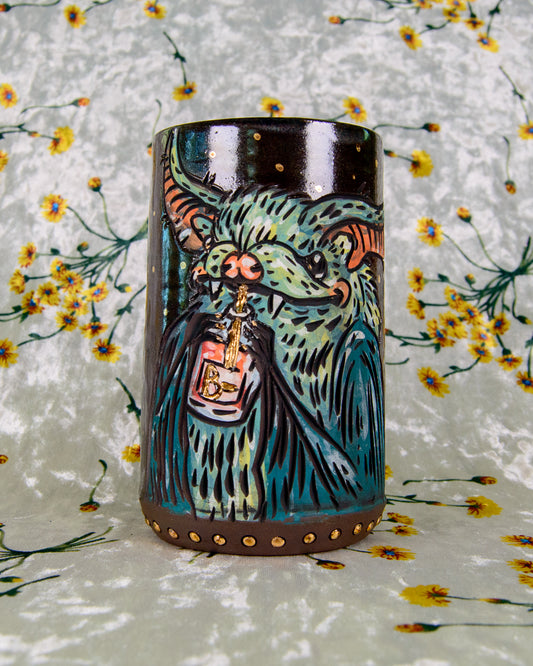 Ceramic mug with a colorful design of a bat drinking out of a blood bag with a golden straw on a floral background