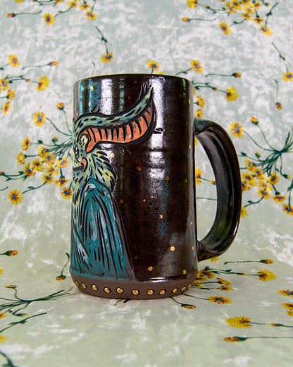 Decorative ceramic mug with a bat design on a floral-patterned background