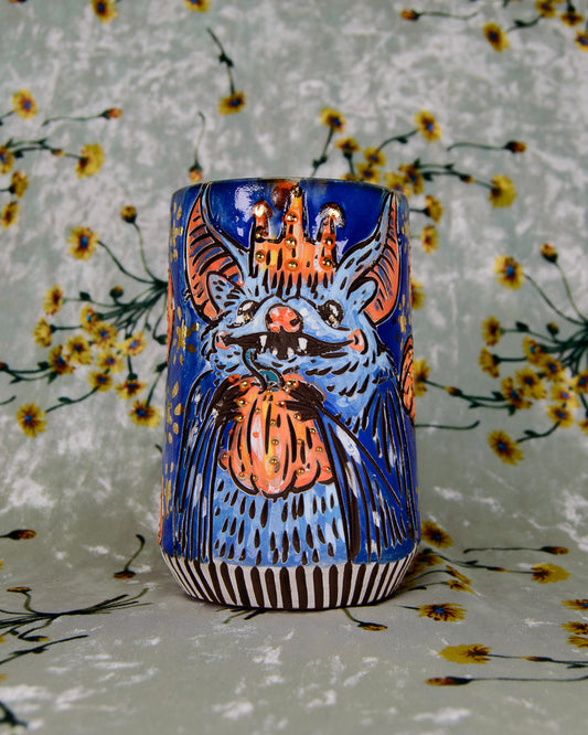 Handmade ceramic mug with a cute cartoon bat design and halloween pumpkins with gold details