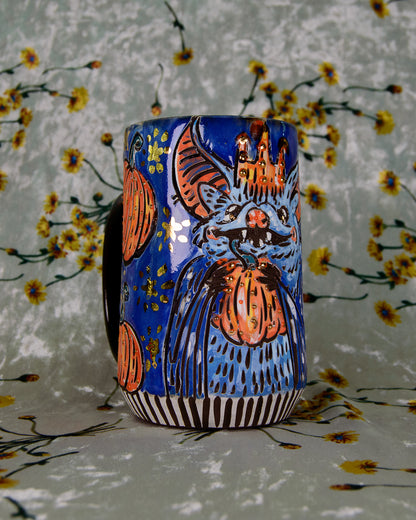 Ceramic mug with a colorful bat design and shiny gold stars on a floral background