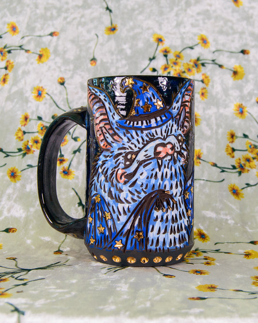 Ceramic mug with a blue and and gold bat design on a floral background